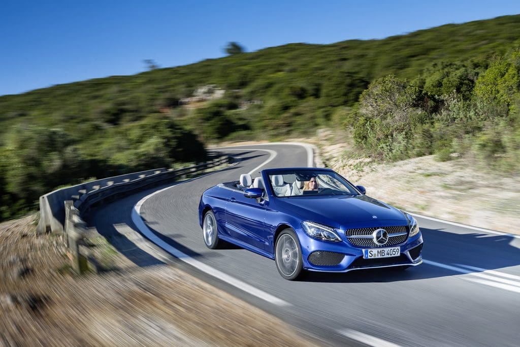 Mercedes-Benz C-Klasse Cabrio an einer kurvigen Straße mit viel Grün.