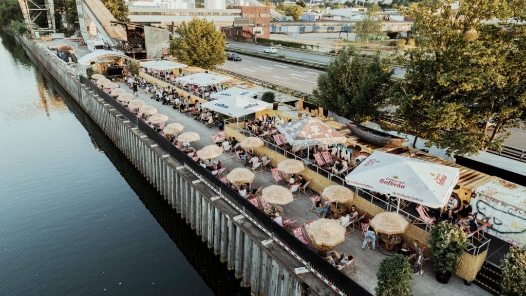 Drohnenaufnahme des Lokals „Fridas Pier“ an Deck eines ehemaligen Frachters