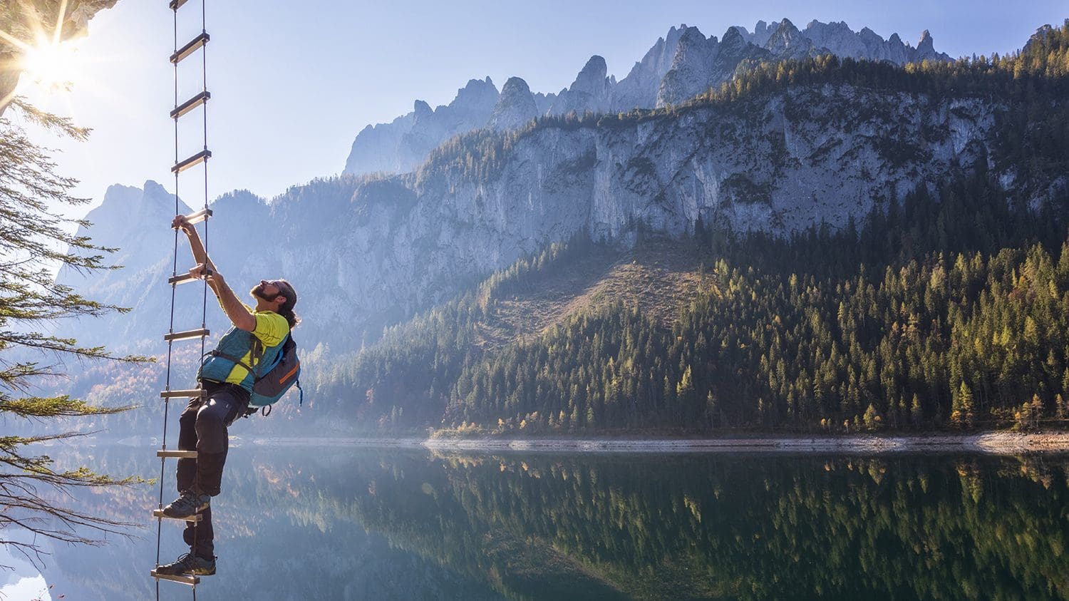 Kletterer auf einer Seilleiter über dem Wasser des Vorderen Gosausees