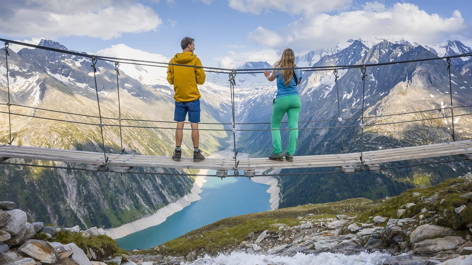 Ein Paar auf der Hängebrücke Olpererhütte vor dem Bergpanorama