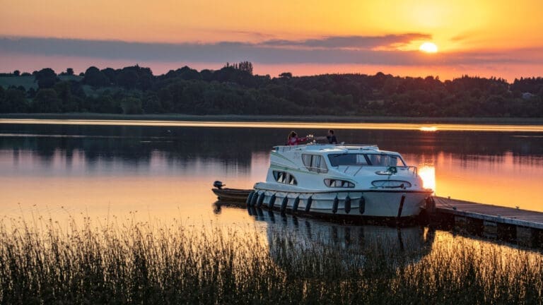 Hausboot an einem Steg in Irland bei Sonnenuntergang
