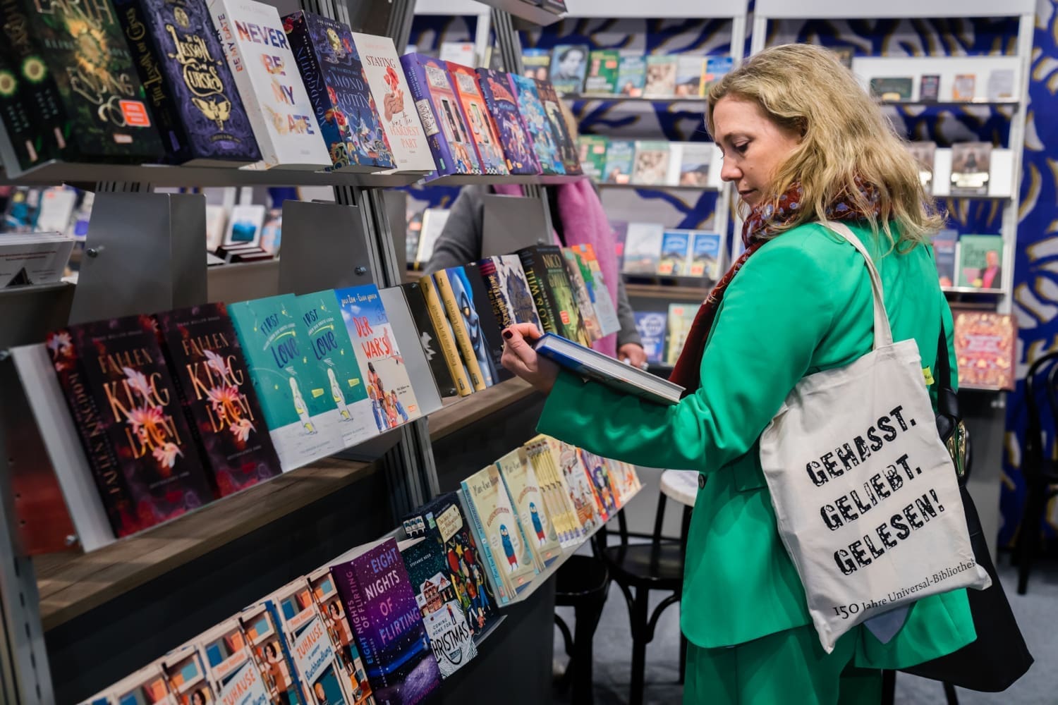 Frau mit Buch vor einem Bücherregal