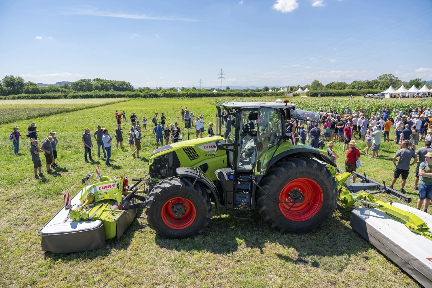 Menschen versammelt um einen Traktor auf einem Feld