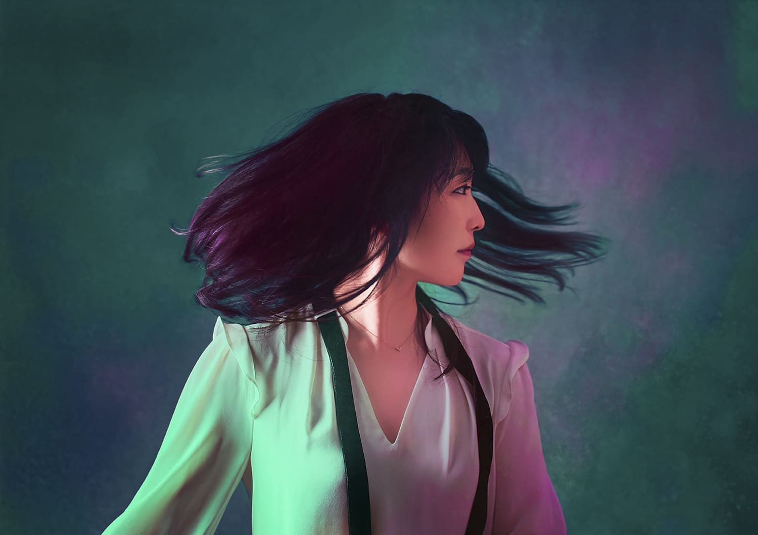 Claire Huangci seitlich vor einem grün-violett-schimmernden Hintergrund