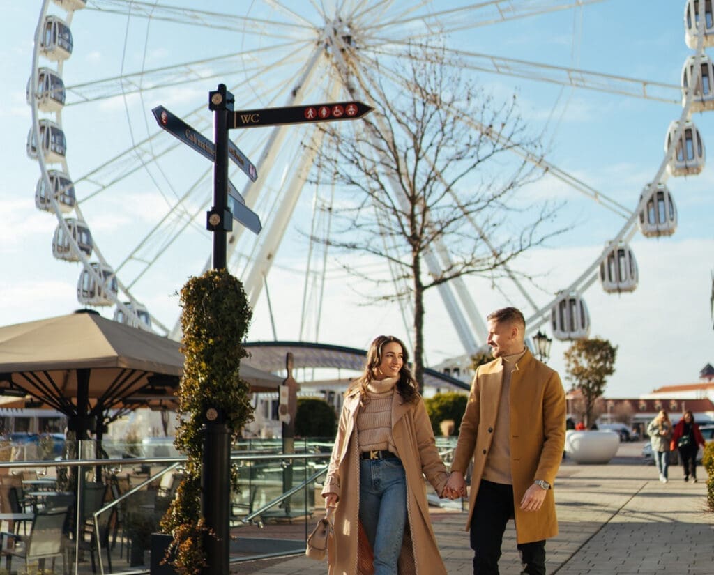 Designer Outlet in Parndorf: Pärchen im Vordergrund im Hintergrund das Riesenrad.