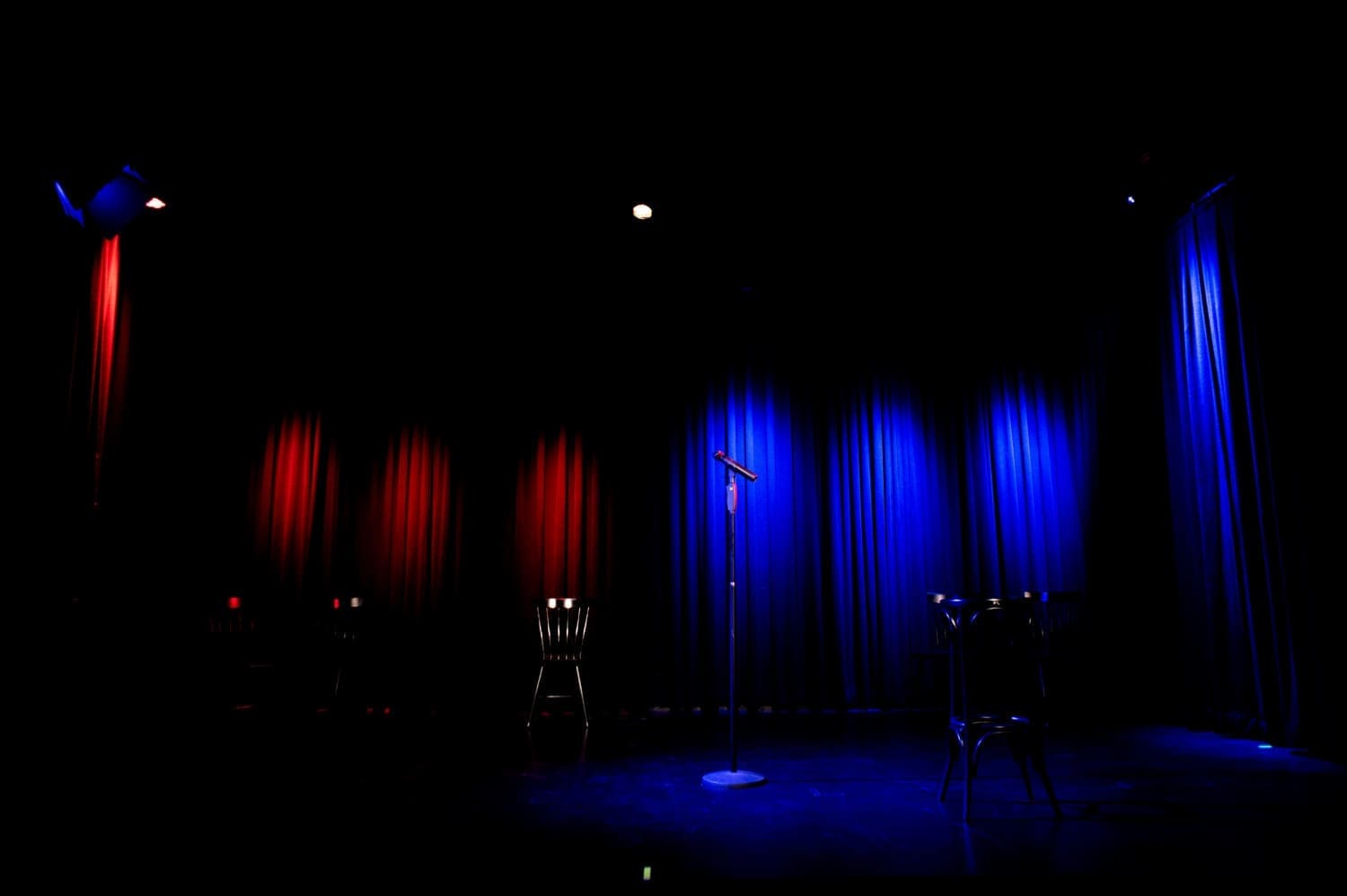 leere Bühne der Kulisse Wien, ein rotes und ein blaues Licht leuchten auf den Vorhang