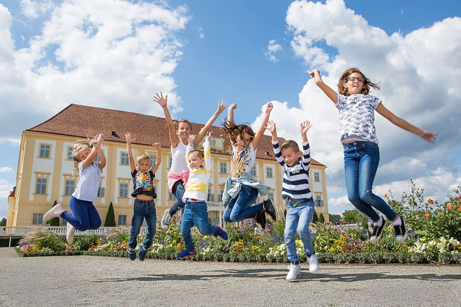 Kinder springen vor Schloss Hof in die Höhe