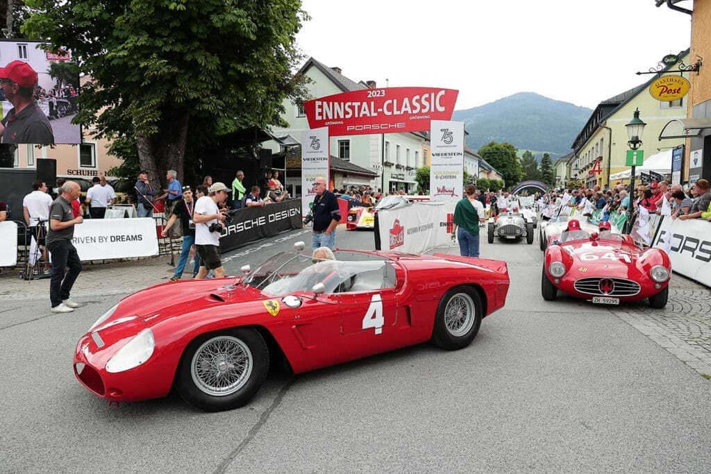 Zwei rote Oldtimer beim Start der Ennstal-Classic