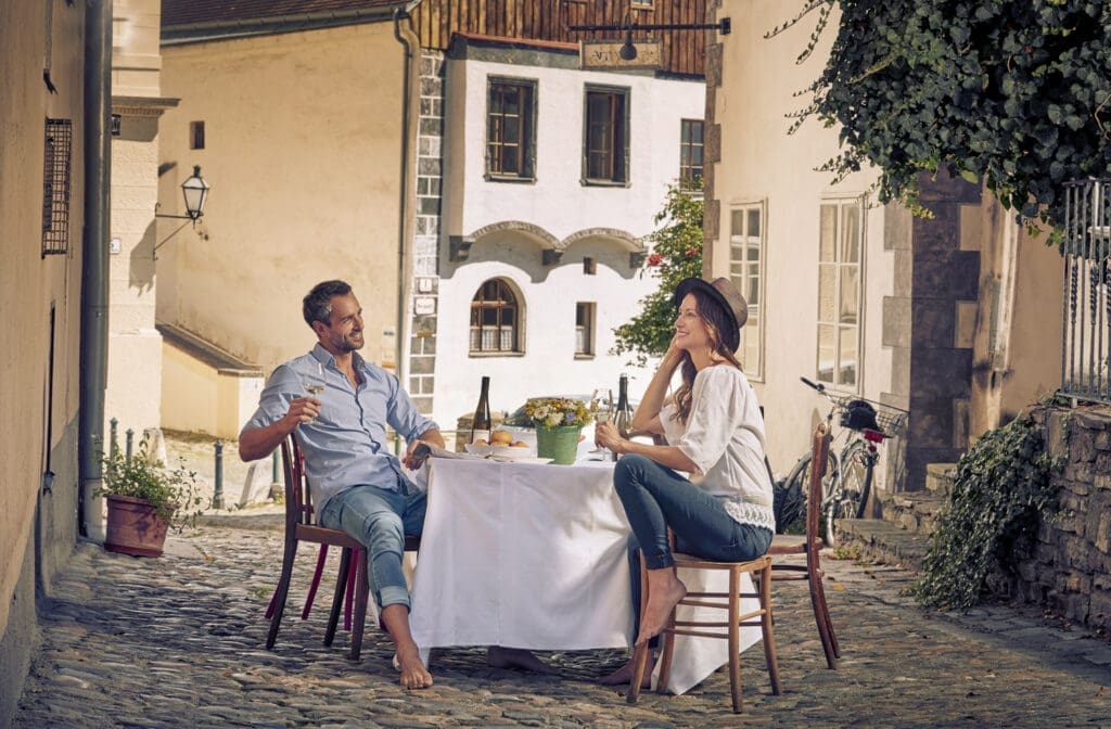 Pärchen sitz an einem Tisch in einer Gasse in der Altstadt von Krems