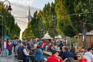 Leute beim Mörbischer Weinfest auf der Hauptstraße mit Kirche im Hintergrund