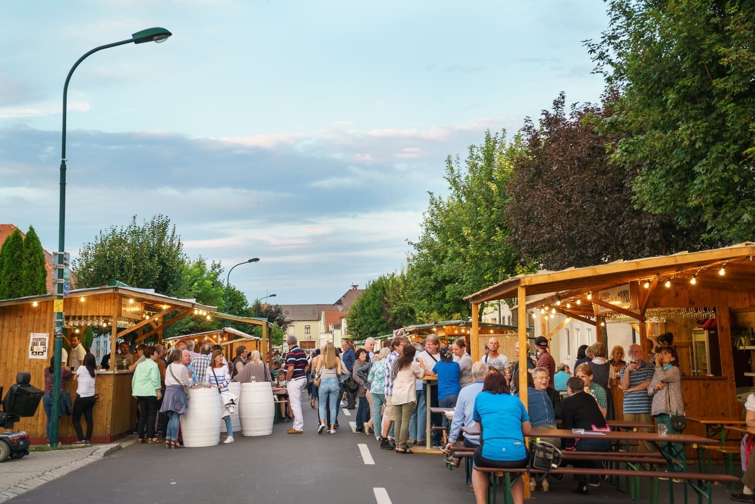 Menschen auf der Straße vor Kojen mit blauem Himmel