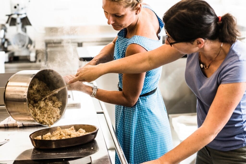 Zwei Frauen stehen in der Küche und kochen Bohnensterz