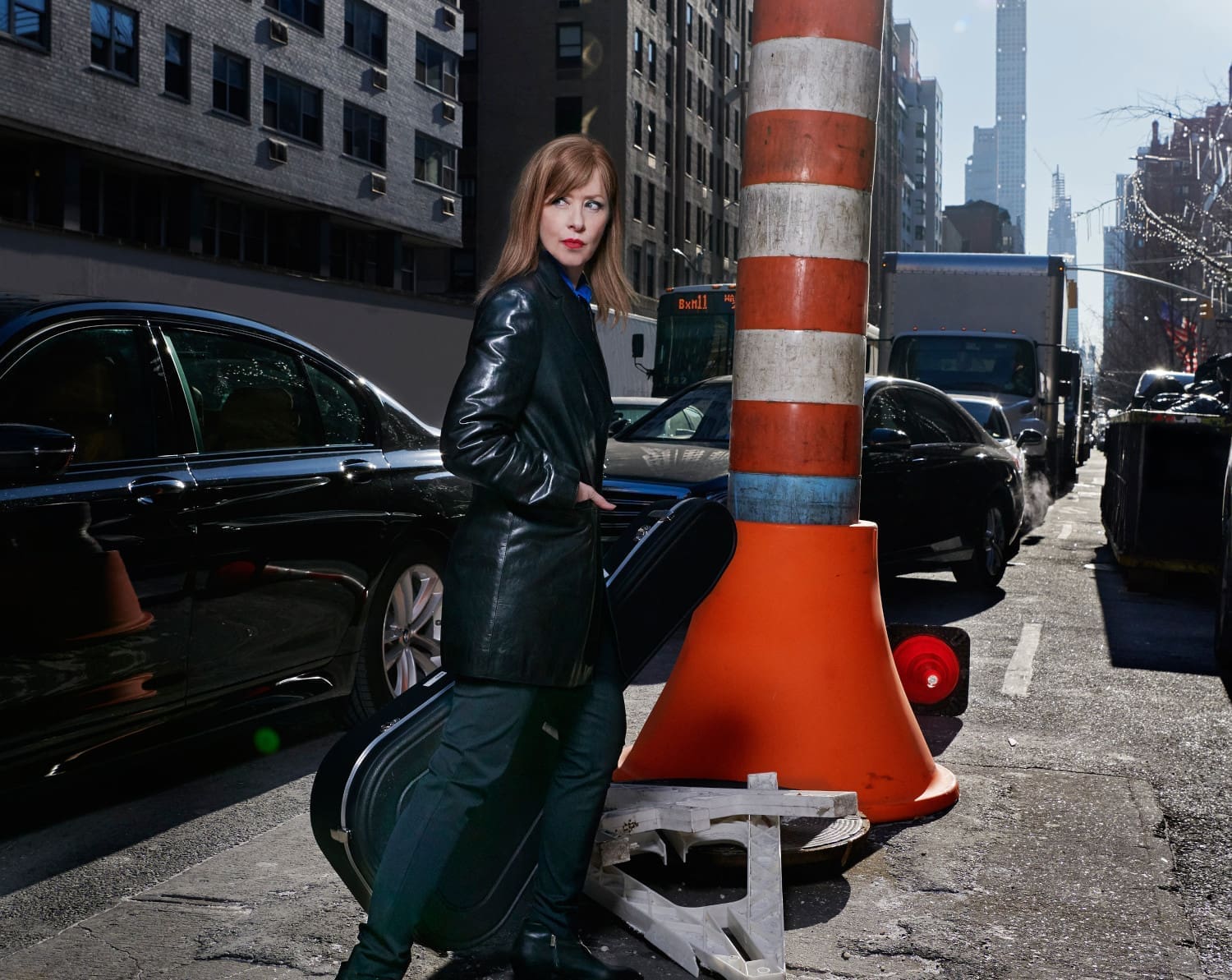 Suzanne Vega auf einer Straße stehend vor einem großen Verkehrshut.
