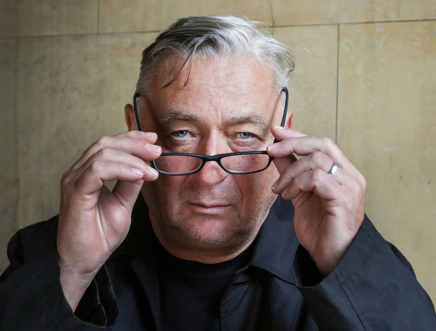 Andreas Vitásek hebt eine Brille von seinem Gesicht.