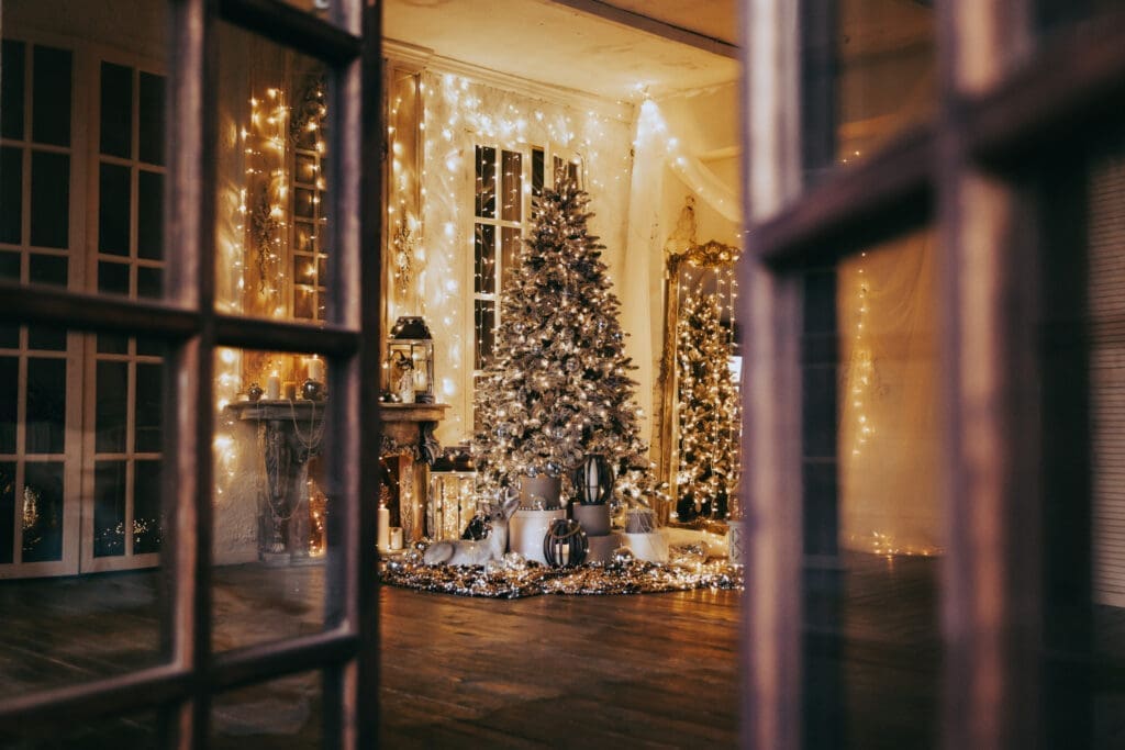 Sicht auf ein weihnachtlich geschmücktes Zimmer mit Weihnachtsbaum und Lichterketten