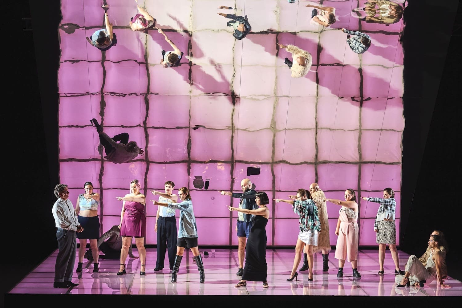 Eine Opernszene „Die Judith von Shimoda“: Sänger zeigen auf einen von ihnen. Im Hintegrund ist die Szene um 90° gedreht gespiegelt. © Anja Koehler