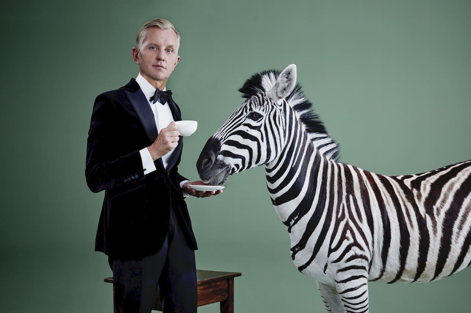 Max Raabe im Anzug mit einer Tasse Tee, neben ihm ein Zebra mit dem Maul in der Untertasse.