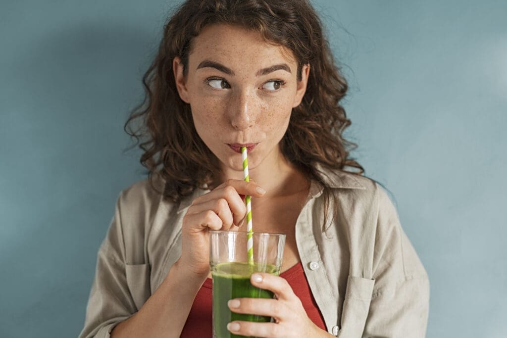 Frau trinkt grünen Smoothie