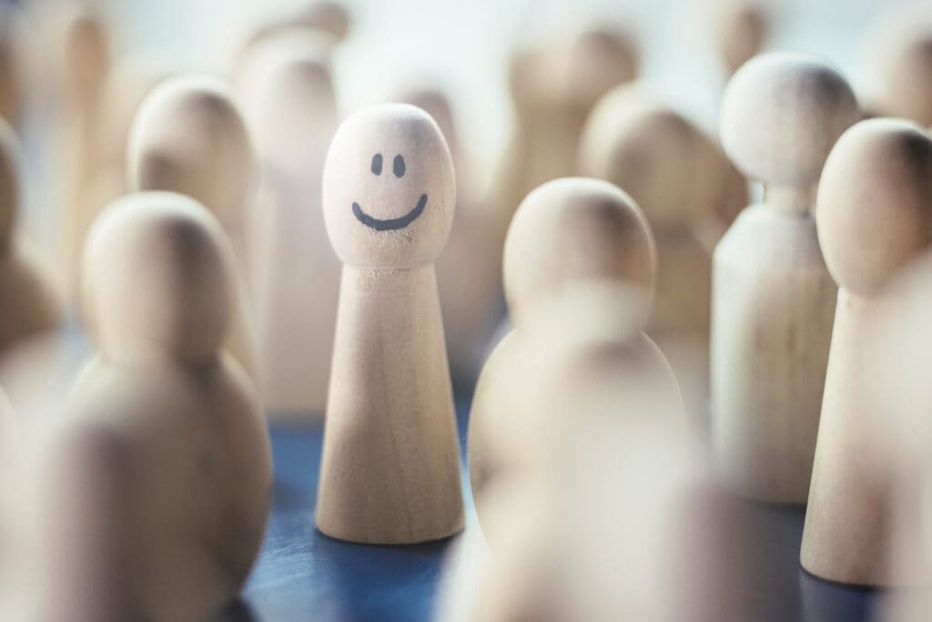 Familienaufstellung symbolisch dargestellt durch Spielfiguren, wobei eine lächelt.