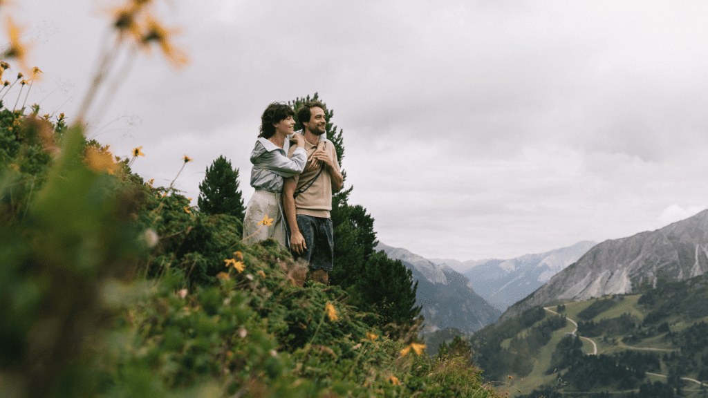 Paar steht auf einer Alm und blickt auf die Bergwelt in Obertauern