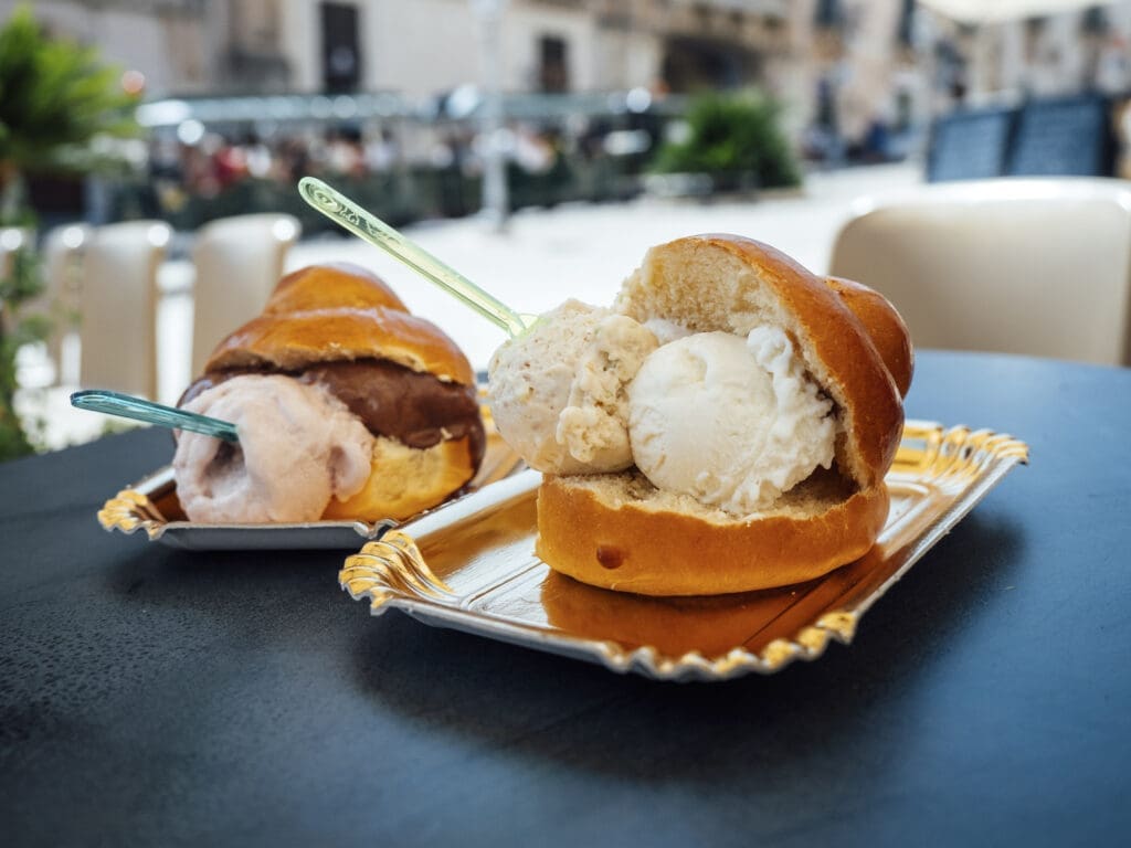 Zwei Brioche con Geloto auf einem schwarzen Tisch