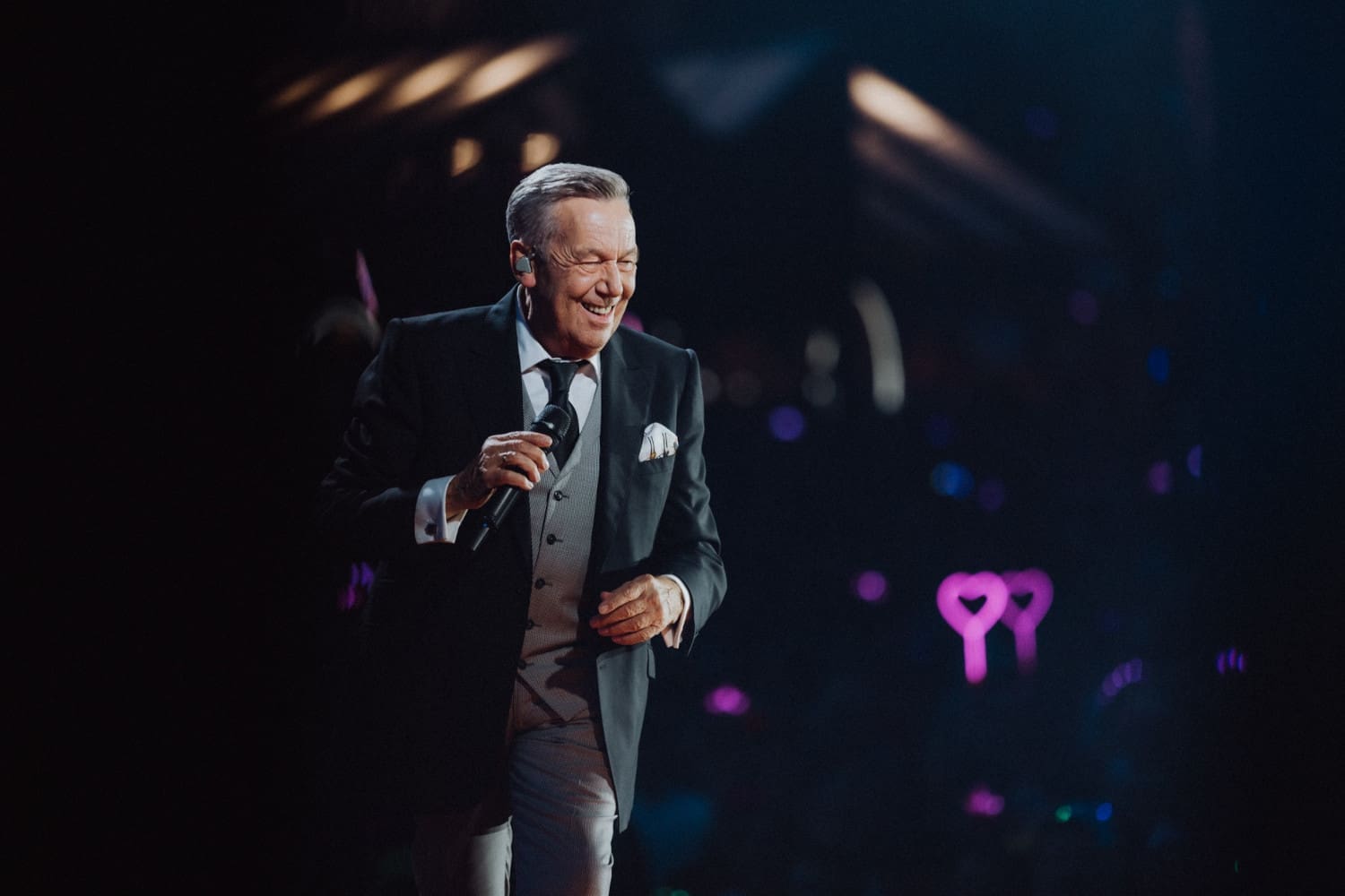 Roland Kaiser im Anzug mit Mikro auf der Bühne