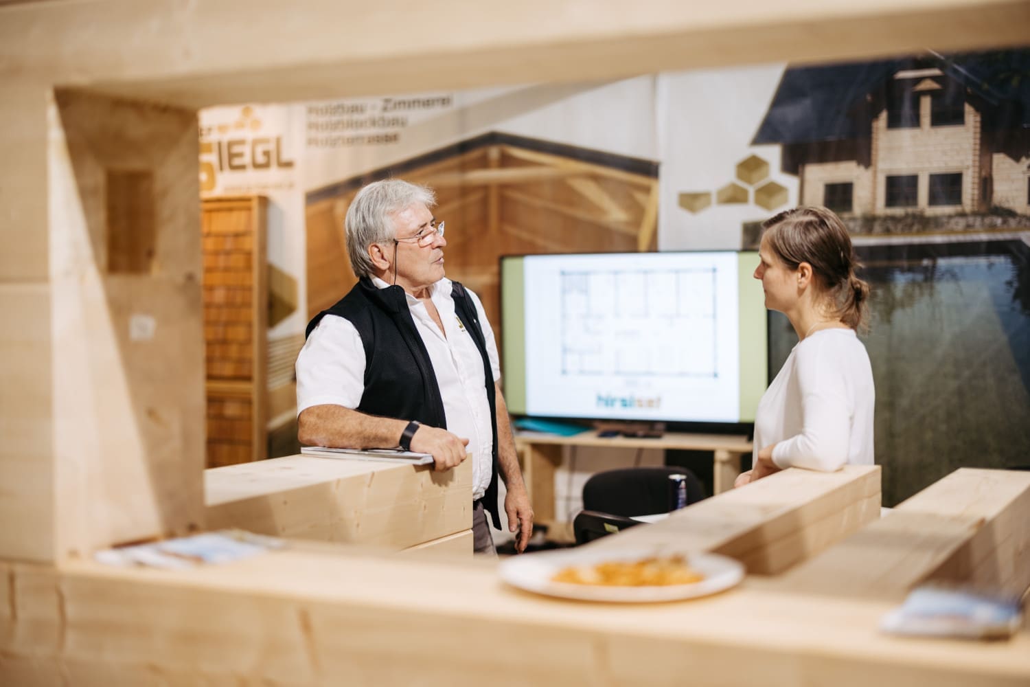 Mann berät auf einer Messe eine Frau