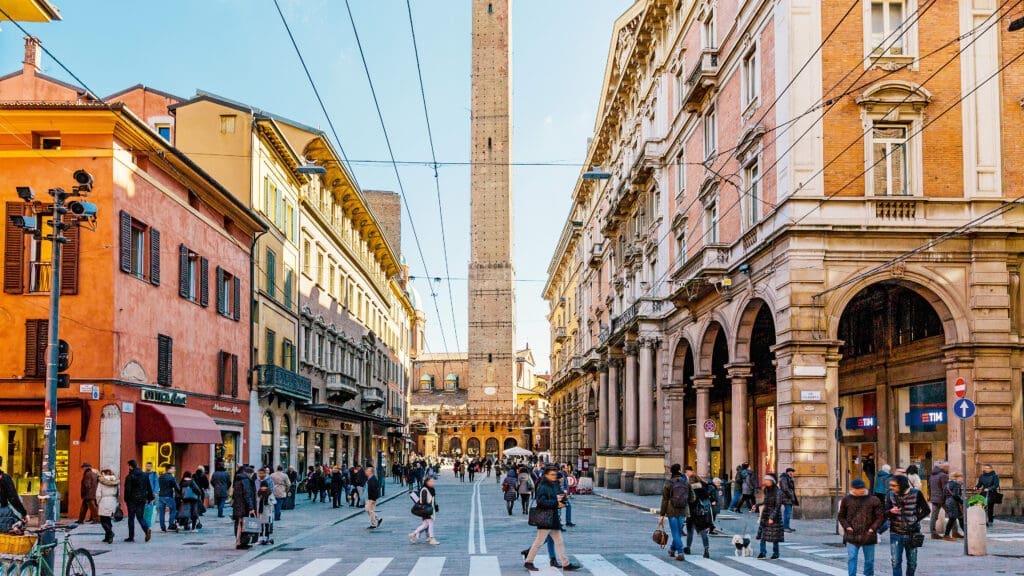 Platz in Bologna mit bunten Häuserfassaden und Turm im Hintergrund