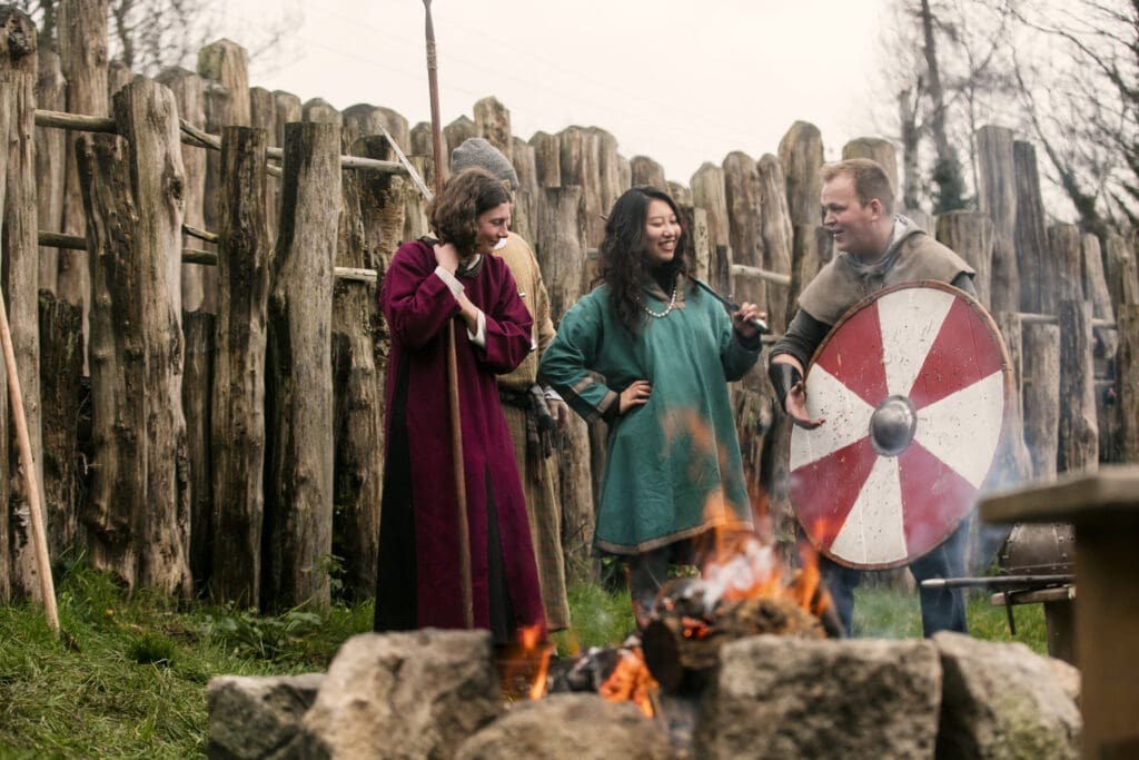 Drei verkleidete Guides vor einem Lagerfeuer