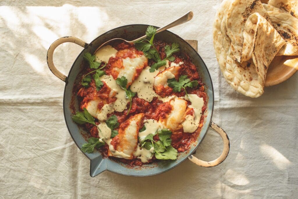 In würziger Tomatensauce gegarter Fisch mit Brot.