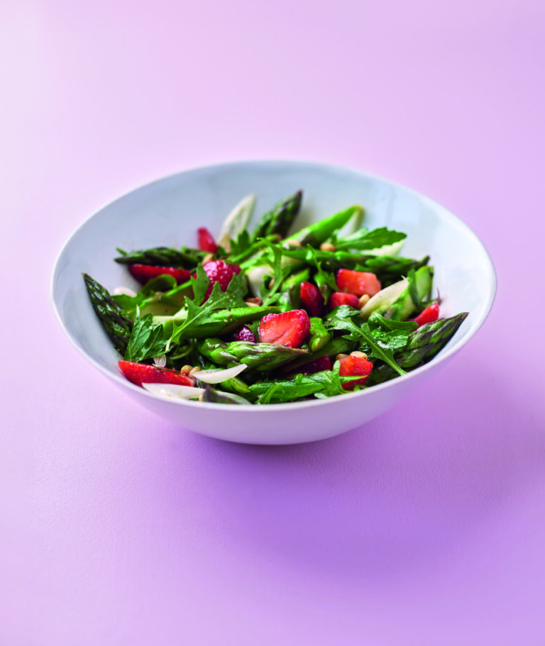 Spargelsalat mit Erdbeeren vor rosa Hintergrund