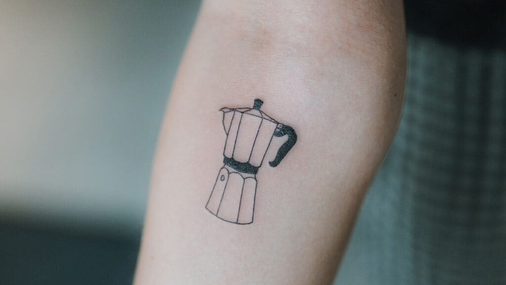 Arm mit Tattoo von Espressokocher