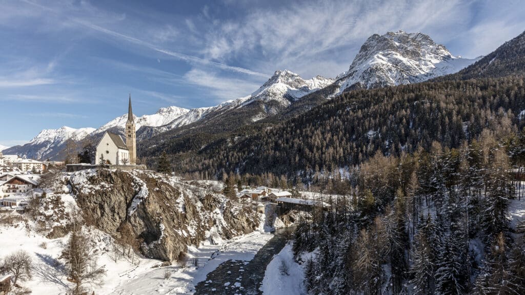 Die evangelische Kirche von Scuol mit umliegender Landschaft