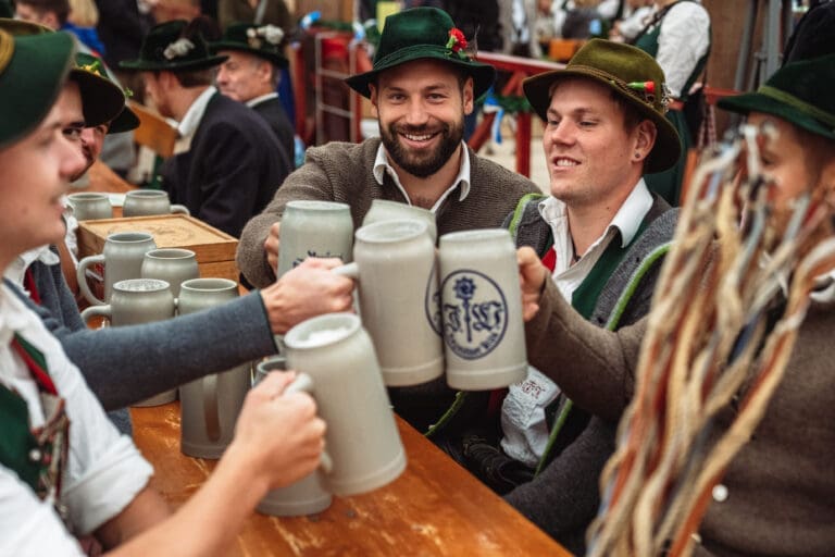 Münchner am Stammtisch mit Bier prostend