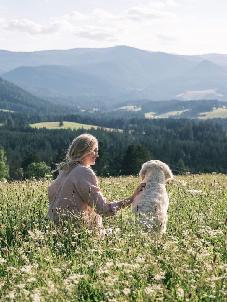 Katharina Miklauz mit ihrem Golden Retriever auf einer Bergwiese