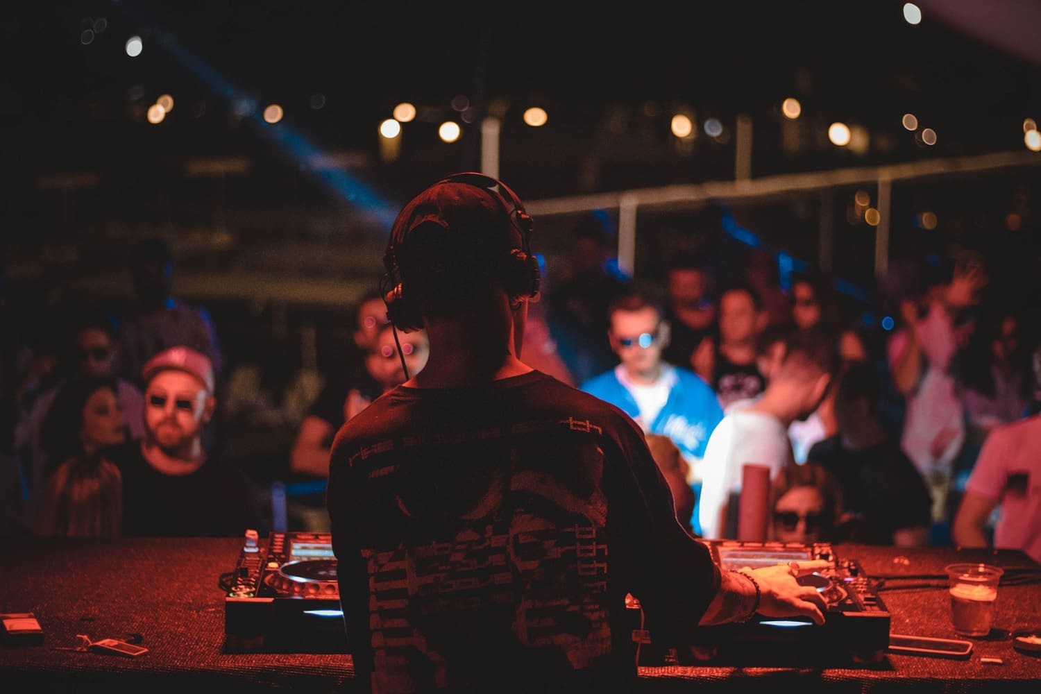 Mann am DJ-Pult legt vor Publikum auf