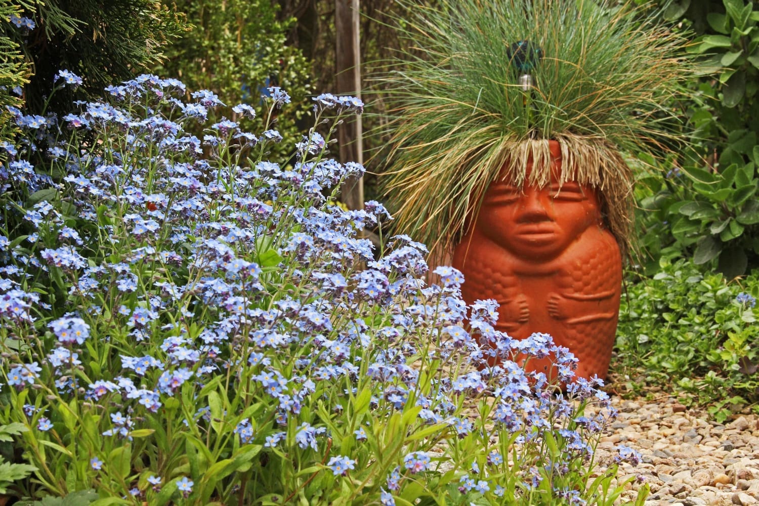 Terrakottafigur in einem Blumengarten