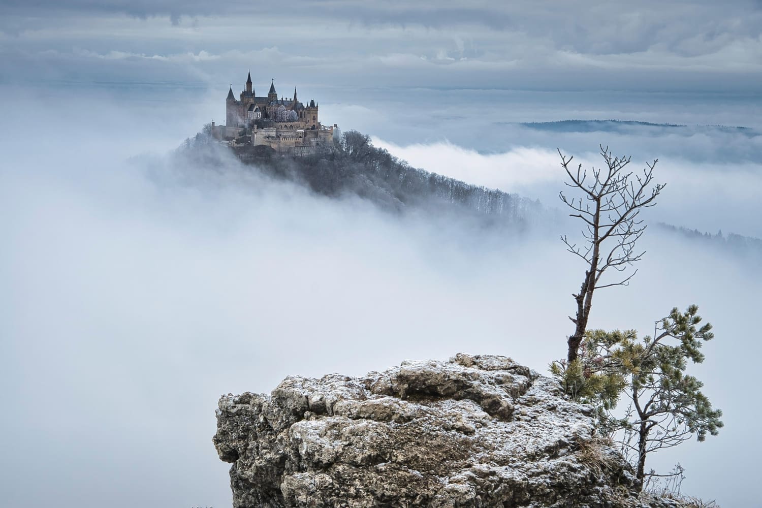 Schloss auf Bergspitze, umgeben von Nebel