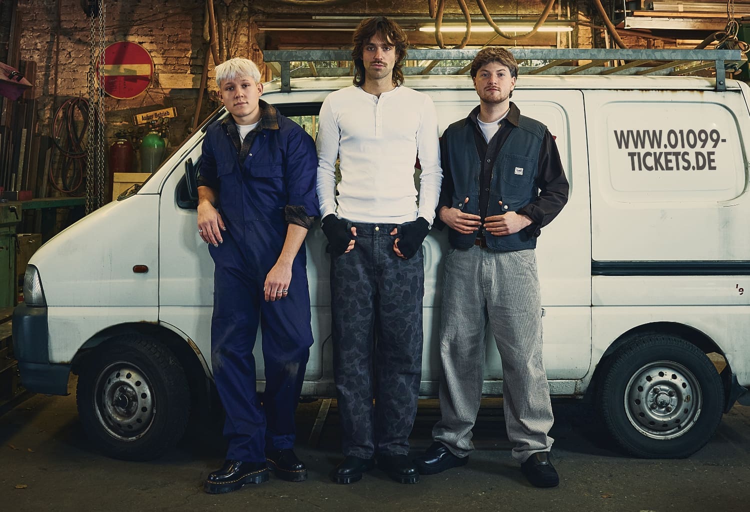 Drei Männer stehen vor einem weißen Van