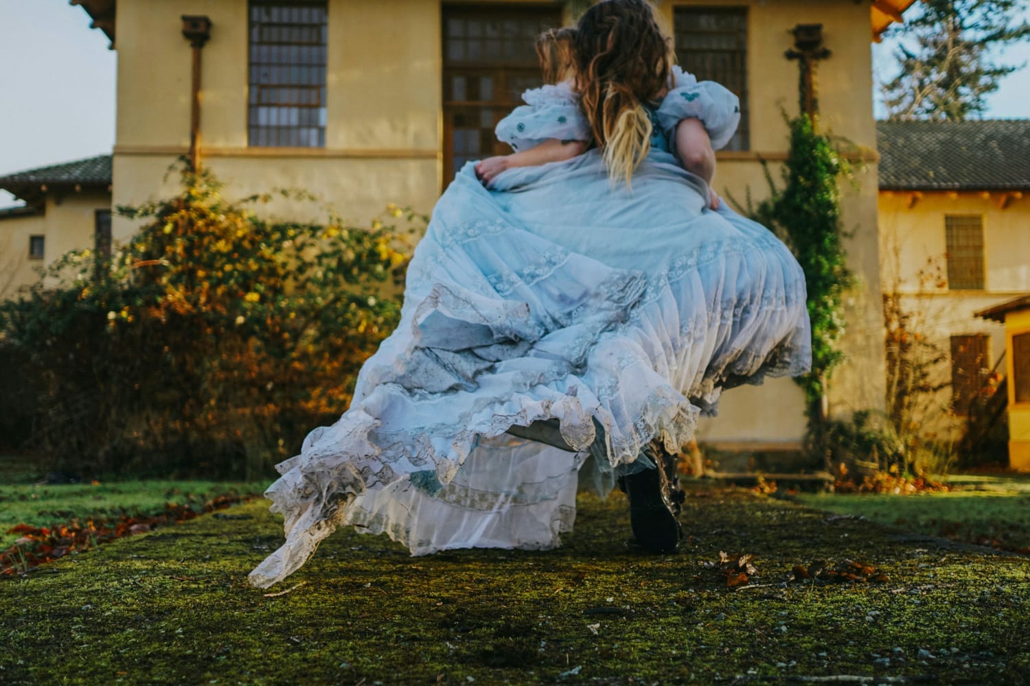 Mädchen in blauem Kleid läuft auf einer Wiese