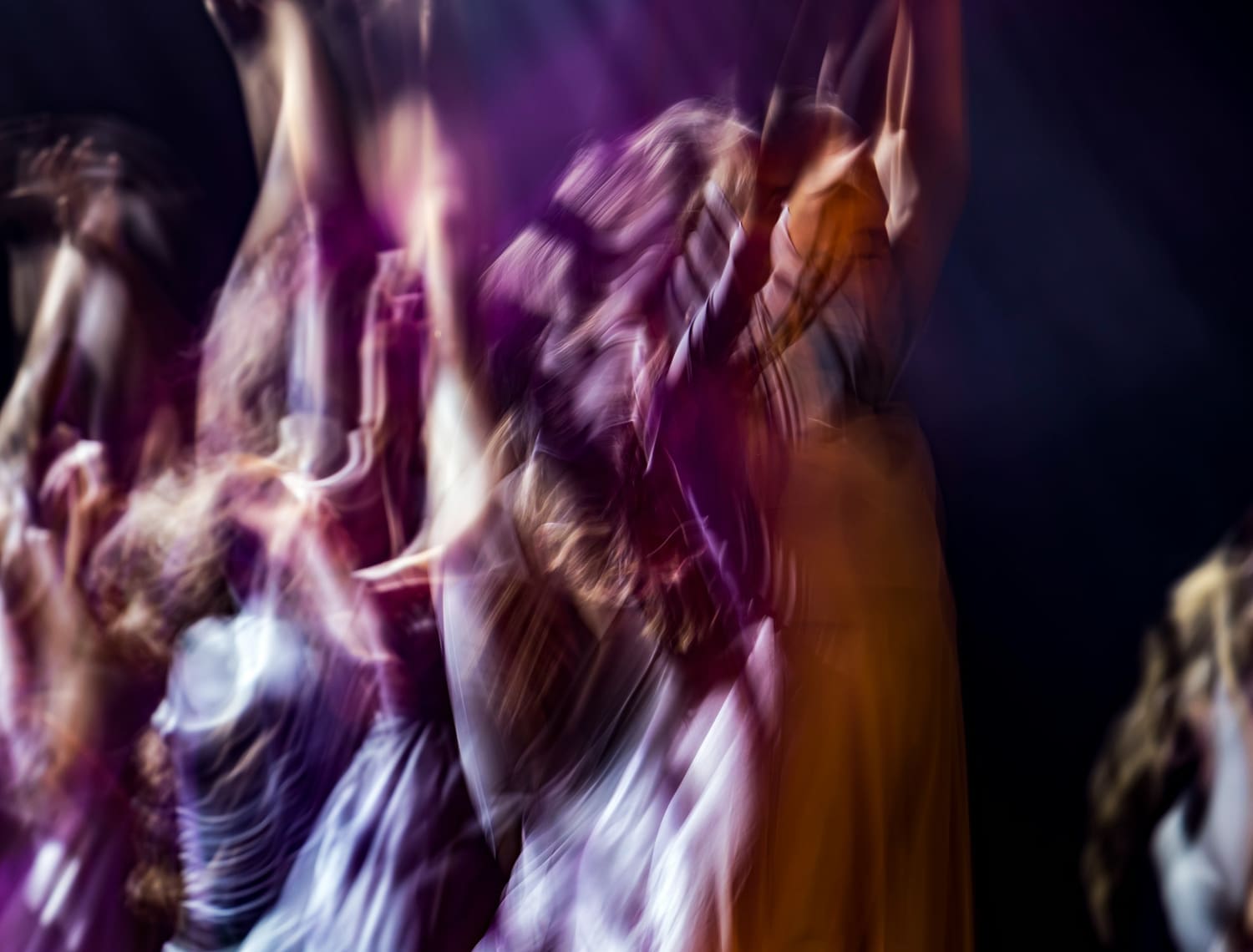 Tanzende Frauen in bunten Kleidern, in Bewegung fotografiert