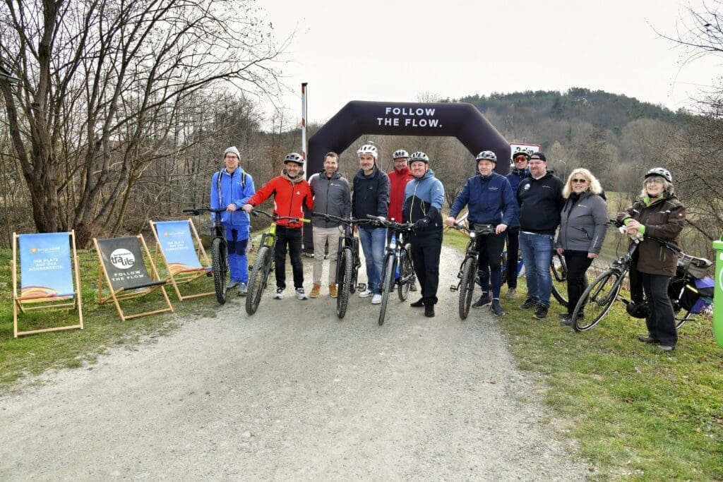Losradeln im Burgenland. Menschen auf Rädern im Grünen vor Bogen