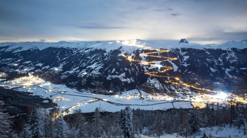 Ansicht der gesamten beleuchteten Rodelstrecke der Wildkogel-Arena Neukirchen Bramberg bei Dämmerung